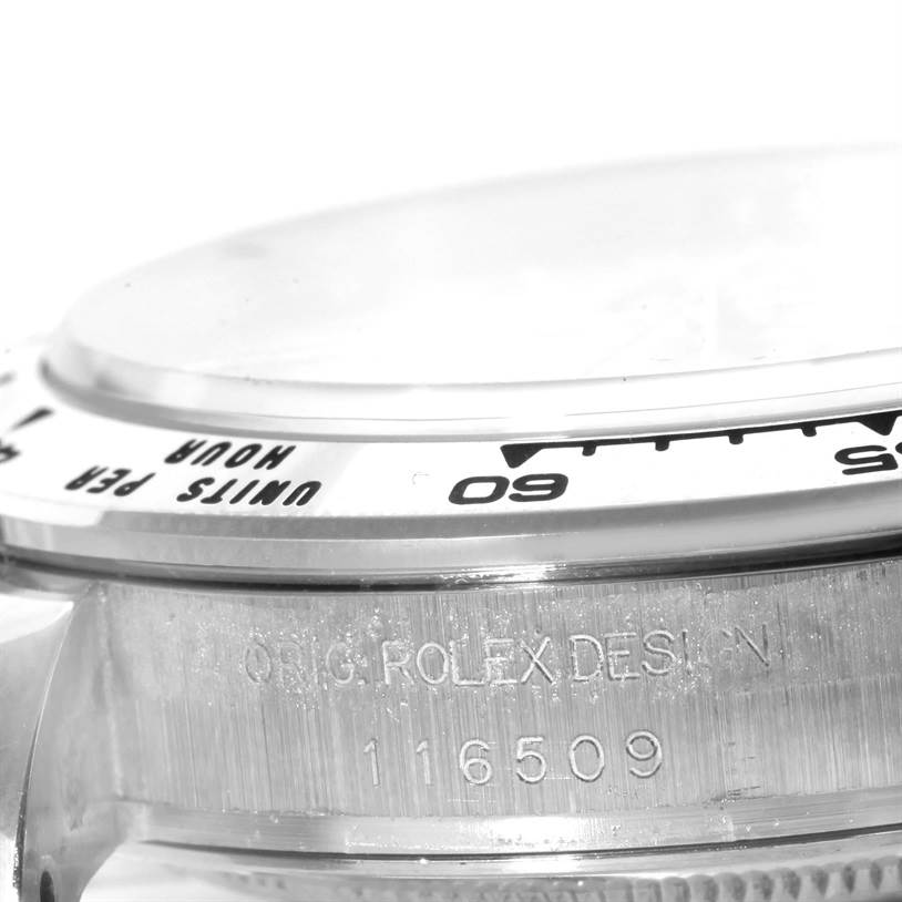 The image shows a close-up of the side and bezel of a Rolex Daytona 116509 Men's White Gold Silver Dial 116509 Men's White Gold Silver Dial watch, highlighting the engraving and parts of the tachymeter scale.