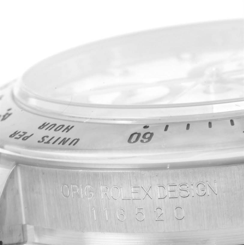 This image shows a close-up side view of the bezel and case side of a Rolex Daytona 116520 Men
s Stainless Steel White Dial 116520 Men
s Stainless Steel White Dial watch, emphasizing its model number and "Orig Rolex Design" engraving.
