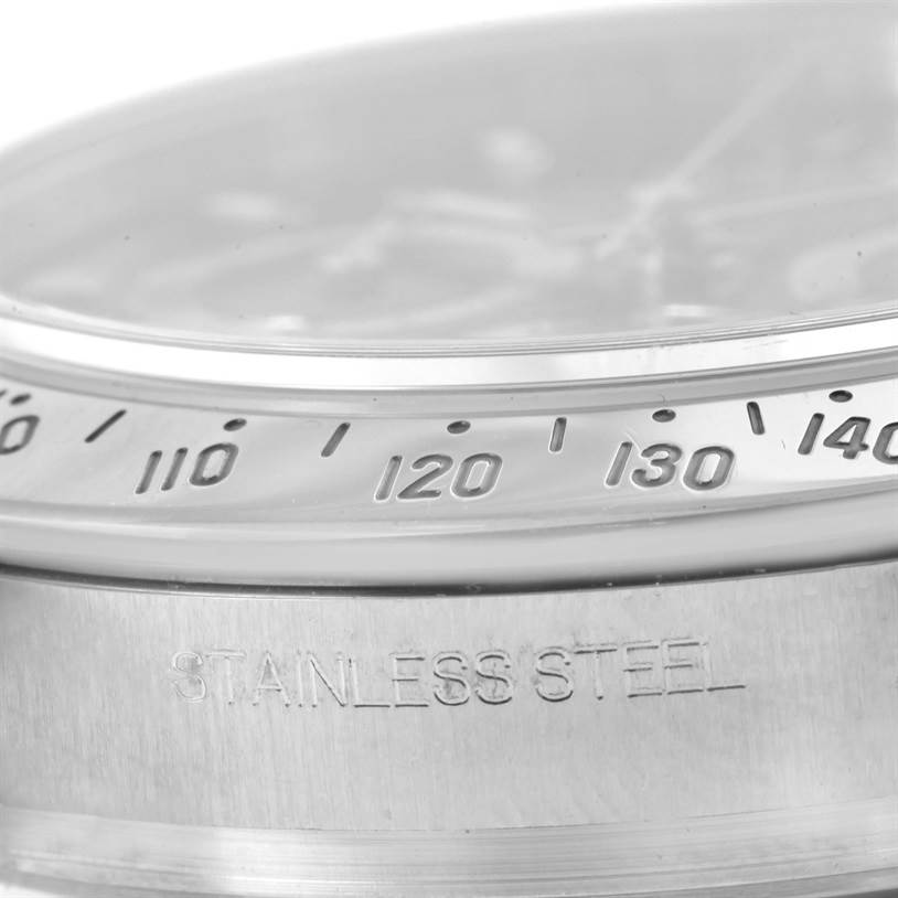 This close-up image shows the bezel and part of the case of a Rolex Daytona 116520 Men
s Stainless Steel Black Dial 116520 Men
s Stainless Steel Black Dial watch, with "STAINLESS STEEL" engraved.