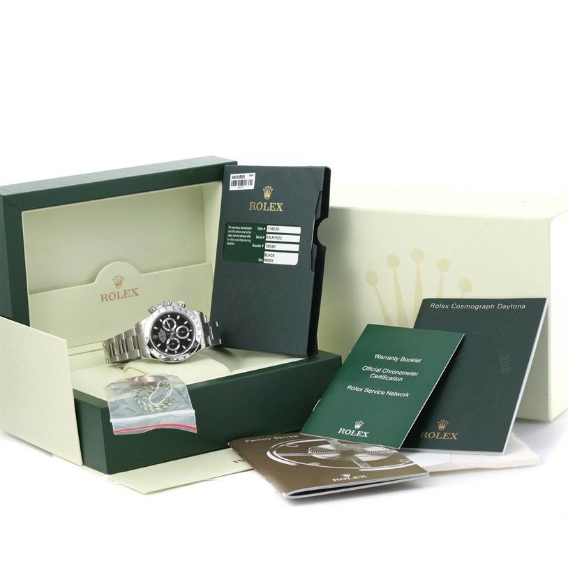 The image shows a Rolex Daytona 116520 Men
s Stainless Steel Black Dial 116520 Men
s Stainless Steel Black Dial watch with its box, manuals, and warranty cards displayed at an angle.