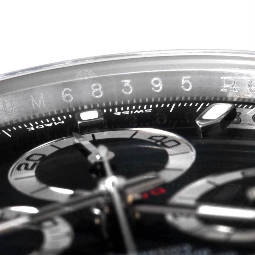 This close-up image shows the Rolex Daytona 116520 Men's Stainless Steel Black Dial 116520 Men's Stainless Steel Black Dial watch face, specifically the chronograph subdials and part of the bezel with serial number.