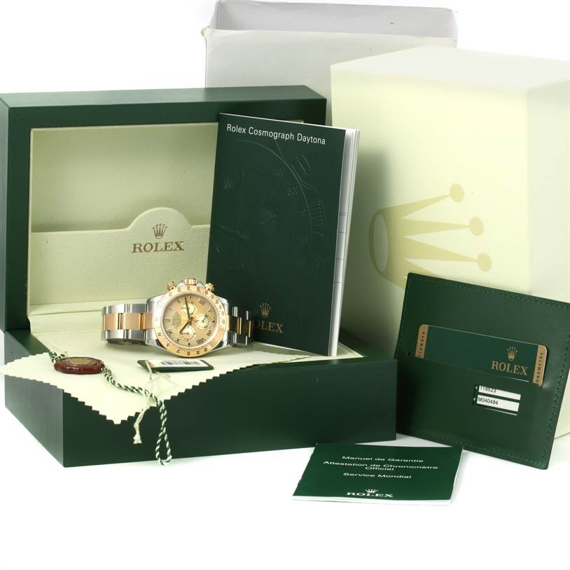 The image shows a Rolex Daytona 116523 Men's Steel and Gold (two tone) Mother of Pearl Dial 116523 Men's Steel and Gold (two tone) Mother of Pearl Dial watch in its box with accompanying booklets, cards, and a hang tag.