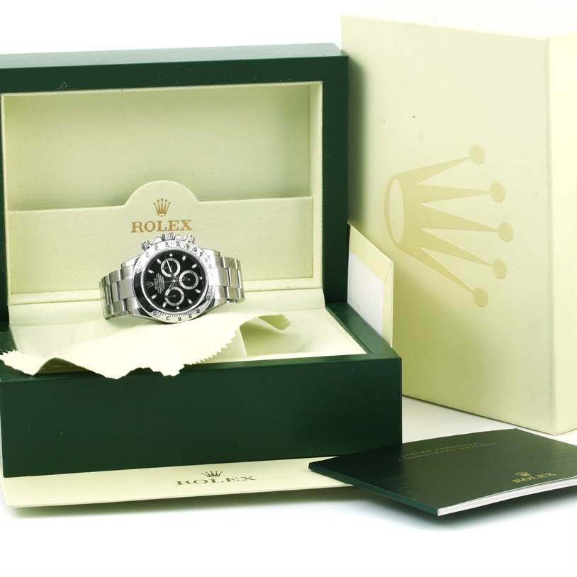 The image shows a Rolex Daytona 116520 Men's Stainless Steel Black Dial 116520 Men's Stainless Steel Black Dial watch in its box with associated packaging and documentation at a front angle.
