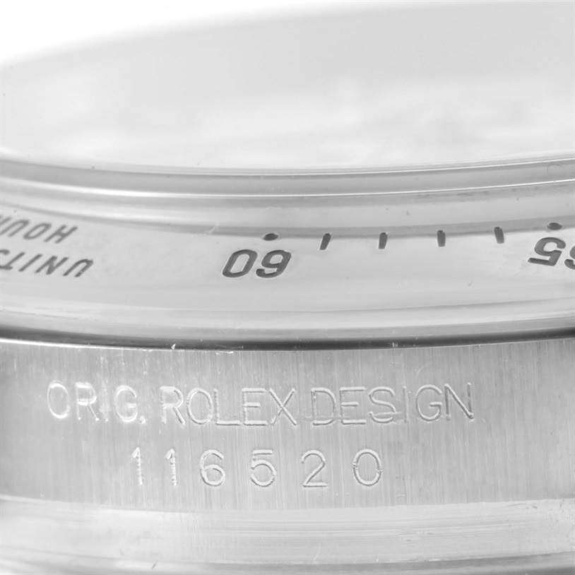 This close-up image of a Rolex Daytona 116520 Men's Stainless Steel White Dial 116520 Men's Stainless Steel White Dial watch shows part of the bezel, the crystal edge, and engraved model number "116520."