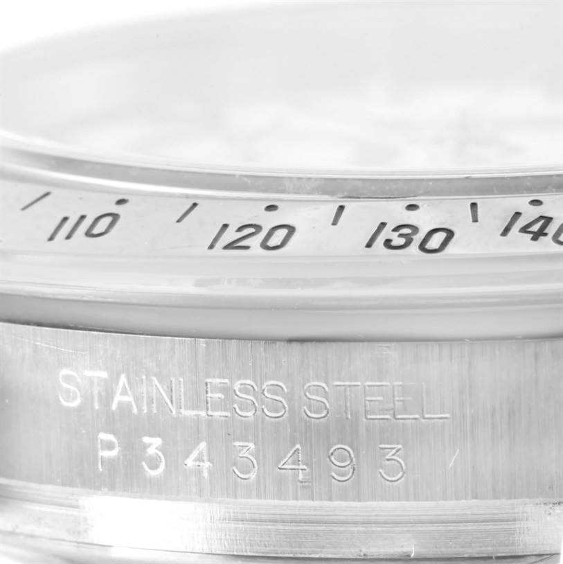 This is a close-up angle showing the bezel and engraved serial number of a Rolex Daytona 116520 Men's Stainless Steel White Dial 116520 Men's Stainless Steel White Dial watch.