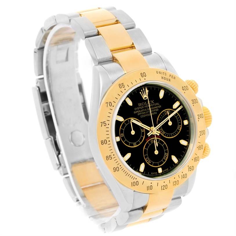 The image shows a Rolex Daytona 116523 Men's Steel and Gold (two tone) Black Dial 116523 Men's Steel and Gold (two tone) Black Dial watch at a slight angle, highlighting its black dial, gold bezel, and two-tone bracelet.