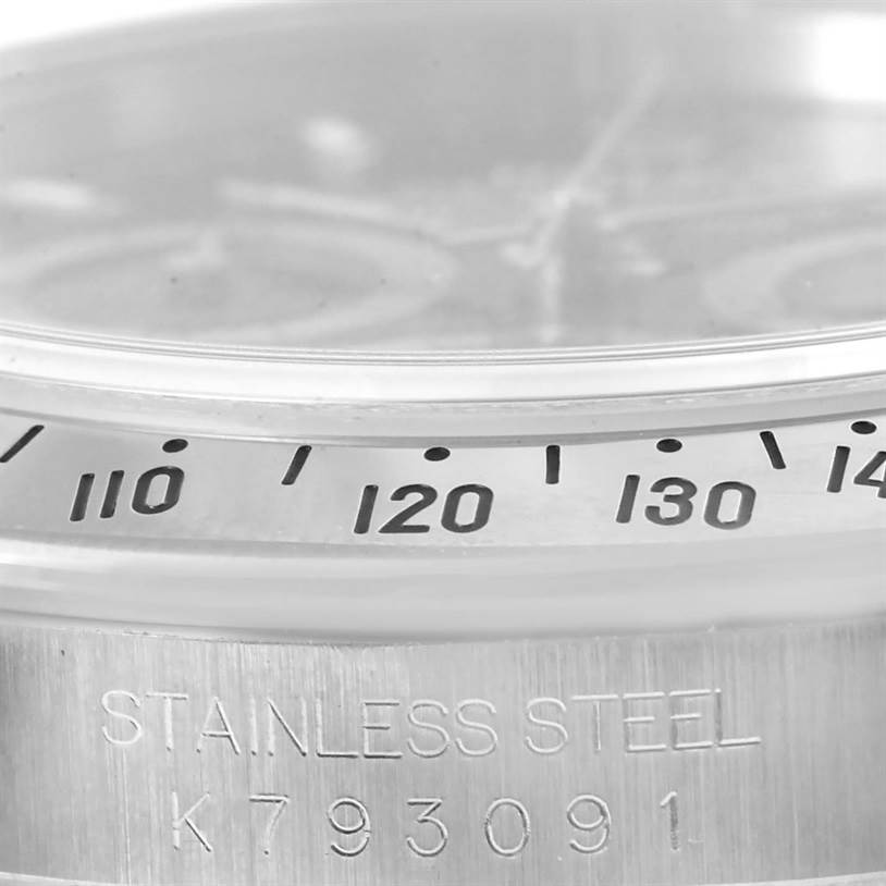 This image shows a close-up of the bezel and case edge of a Rolex Daytona 116520 Men's Stainless Steel Black Dial 116520 Men's Stainless Steel Black Dial watch, focusing on the engraved serial number and tachymeter scale.