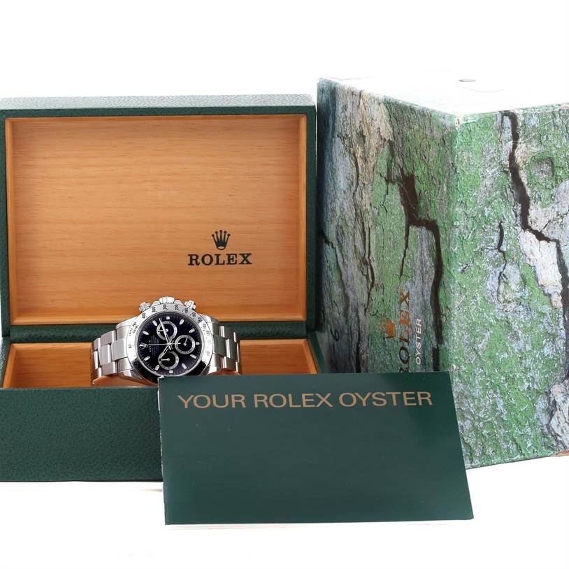 The Rolex Daytona 116520 Men
s Stainless Steel Black Dial 116520 Men
s Stainless Steel Black Dial watch is displayed in its open box with packaging and a booklet visible.