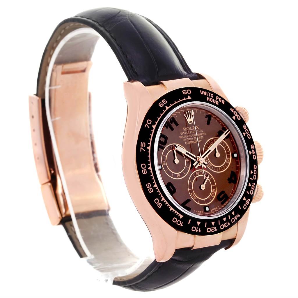 The image shows a Rolex Daytona 116515LN Men
s Rose Gold Brown Dial 116515LN Men
s Rose Gold Brown Dial watch at an angle displaying its face, bezel, pushers, and leather strap.