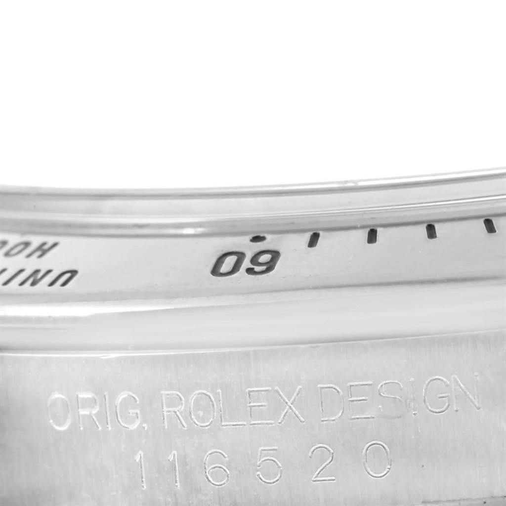 This close-up image shows the bezel and case of a Rolex Daytona 116520 Men
s Stainless Steel White Dial 116520 Men
s Stainless Steel White Dial watch, displaying engravings and part of the tachymeter scale.