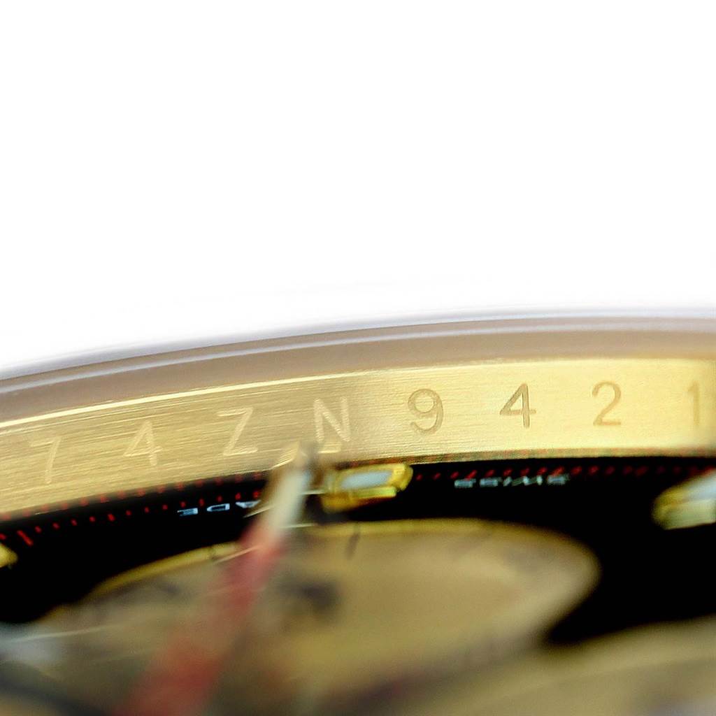 The image shows a close-up angle of the bezel and part of the dial of a Rolex Daytona 116528 Men's Yellow Gold Black Dial 116528 Men's Yellow Gold Black Dial watch.