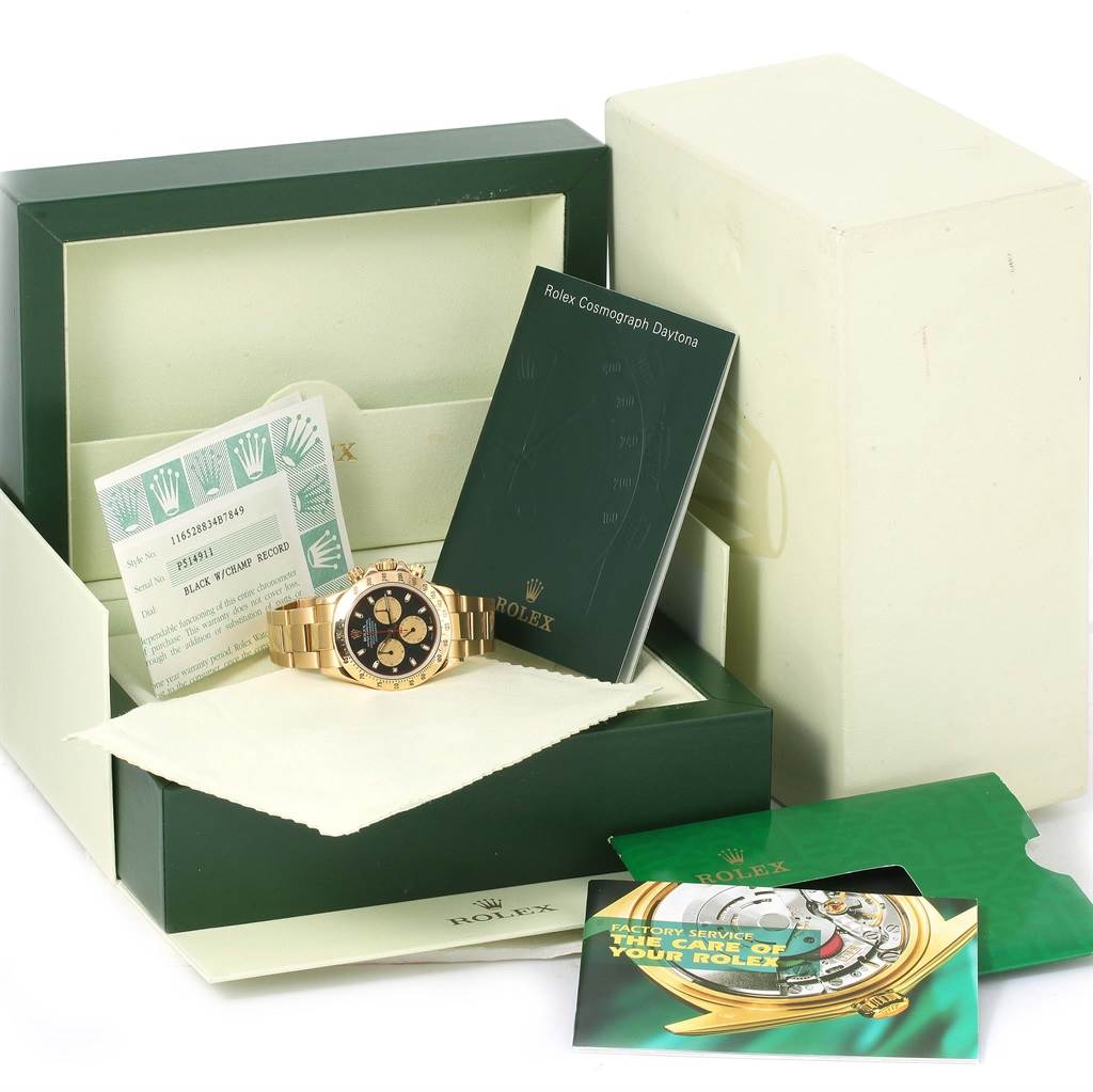 This image shows a Rolex Daytona 116528 Men's Yellow Gold Black Dial 116528 Men's Yellow Gold Black Dial watch in its box, surrounded by documentation and manuals.