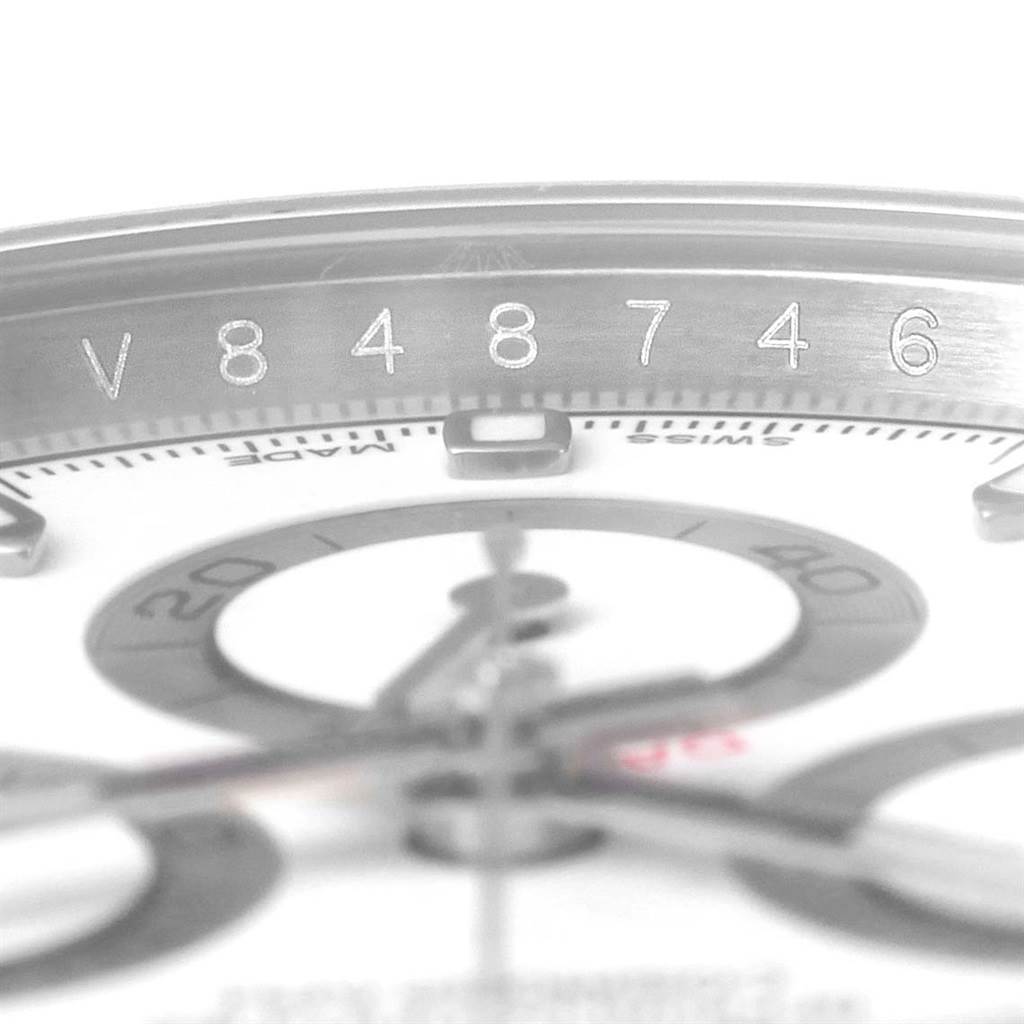 The image shows a close-up of the serial number and part of the dial of a Rolex Daytona 116520 Men's Stainless Steel White Dial 116520 Men's Stainless Steel White Dial watch.