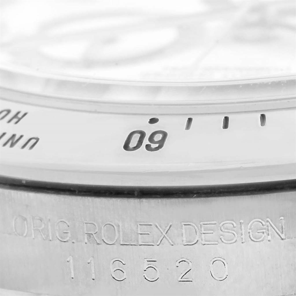 This close-up shows the bezel and engraved casing of a Rolex Daytona 116520 Men
s Stainless Steel White Dial 116520 Men
s Stainless Steel White Dial watch, including the model number.