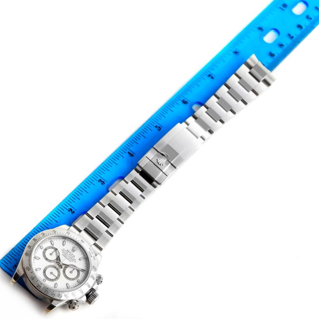 The image shows a Rolex Daytona 116520 Men's Stainless Steel White Dial 116520 Men's Stainless Steel White Dial watch laid flat with a ruler for size reference.