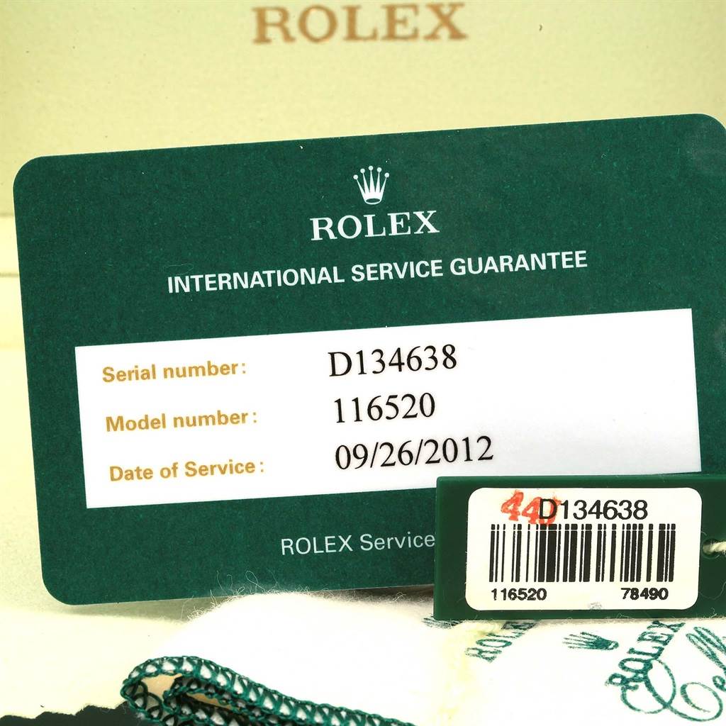 The image shows the international service guarantee card and a tag with a serial number for the Rolex Daytona 116520 Men's Stainless Steel Black Dial 116520 Men's Stainless Steel Black Dial model 116520.