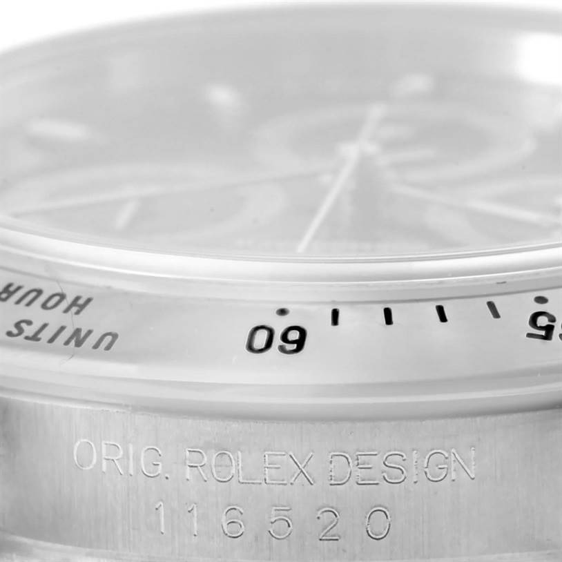 This image shows a close-up angle of the bezel and engraved serial number on the case of a Rolex Daytona 116520 Men's Stainless Steel Black Dial 116520 Men's Stainless Steel Black Dial model watch.