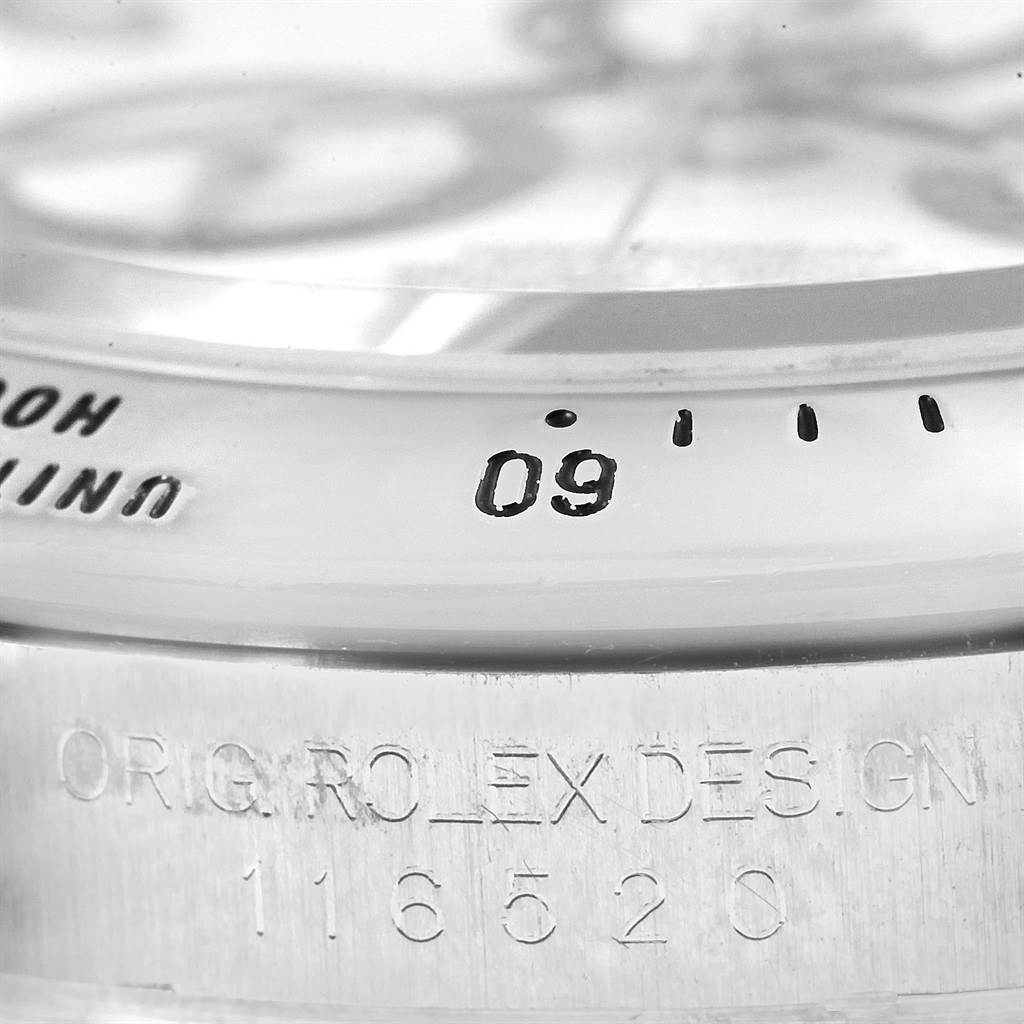 This close-up angle shows the bezel, inscription, and part of the dial of a Rolex Daytona 116520 Men's Stainless Steel White Dial 116520 Men's Stainless Steel White Dial.