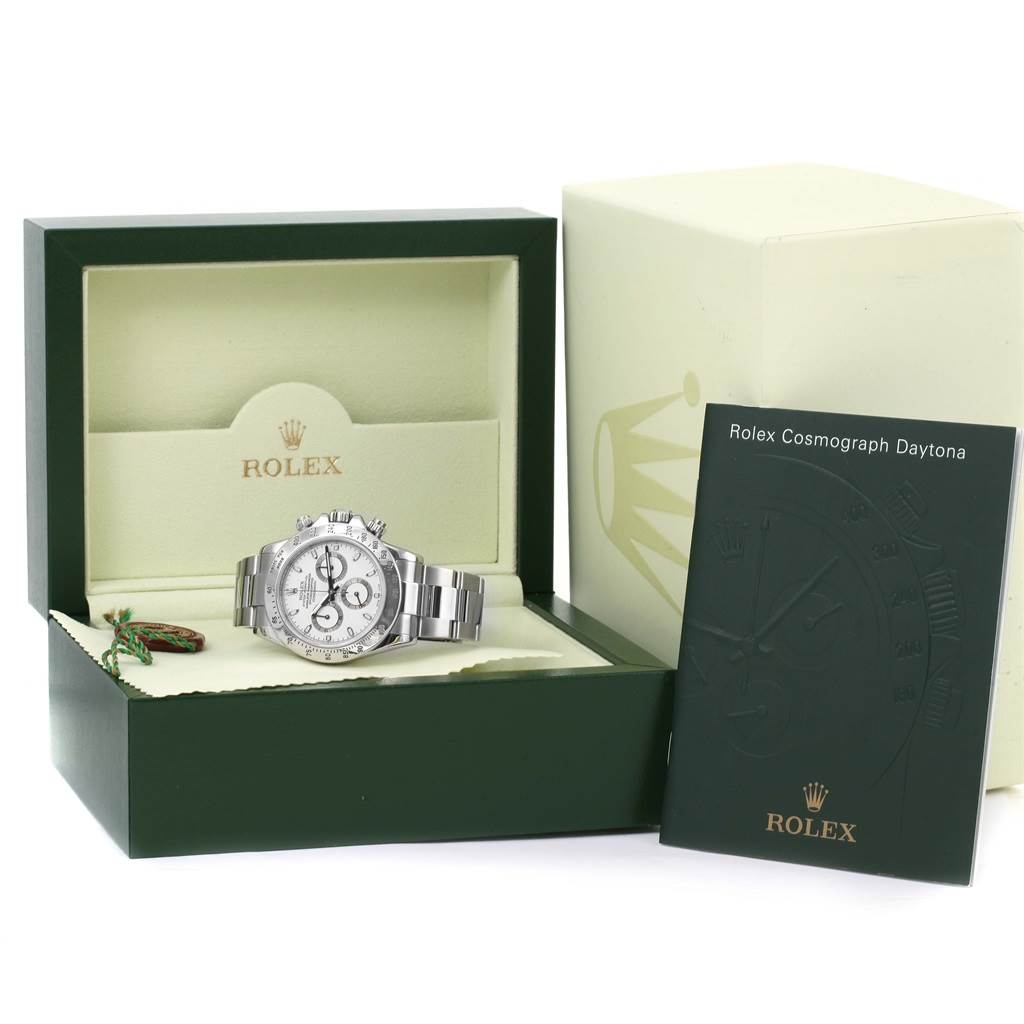 The Rolex Daytona 116520 Men's Stainless Steel White Dial 116520 Men's Stainless Steel White Dial watch is displayed at an angle within its open green and cream box, alongside a booklet and outer box.