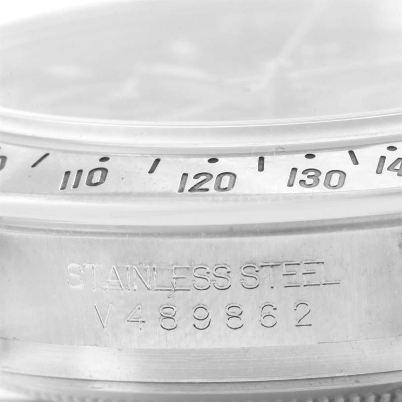 The image shows a close-up of the bezel and serial number engraving on a Rolex Daytona 116520 Men's Stainless Steel Black Dial 116520 Men's Stainless Steel Black Dial watch.