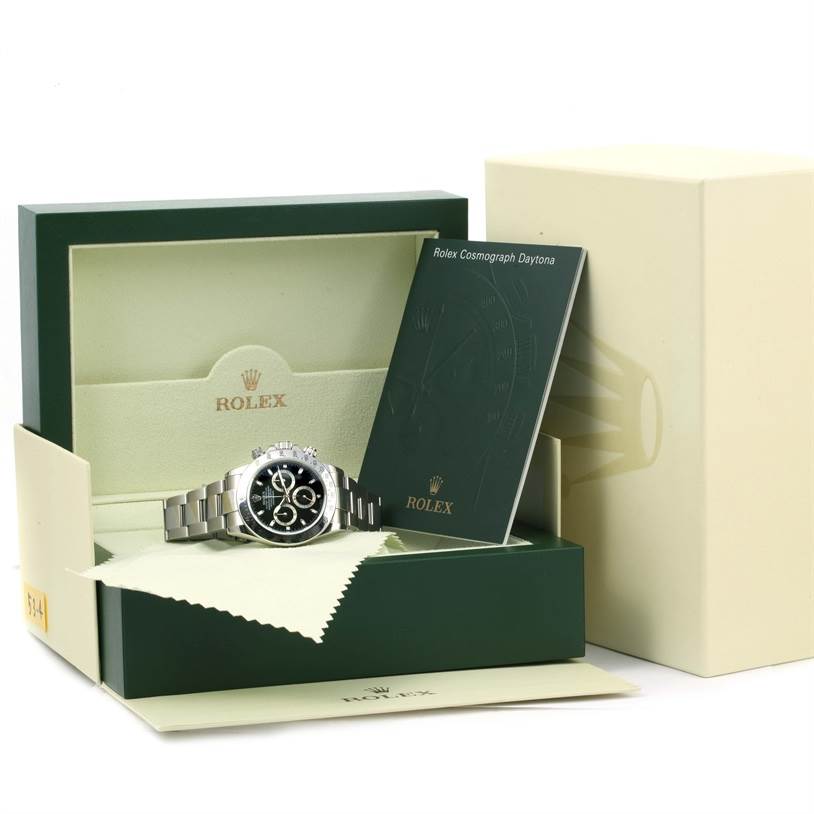 The image shows a Rolex Daytona 116520 Men's Stainless Steel Black Dial 116520 Men's Stainless Steel Black Dial watch from a front angle, displayed in its box with accompanying booklet and packaging.