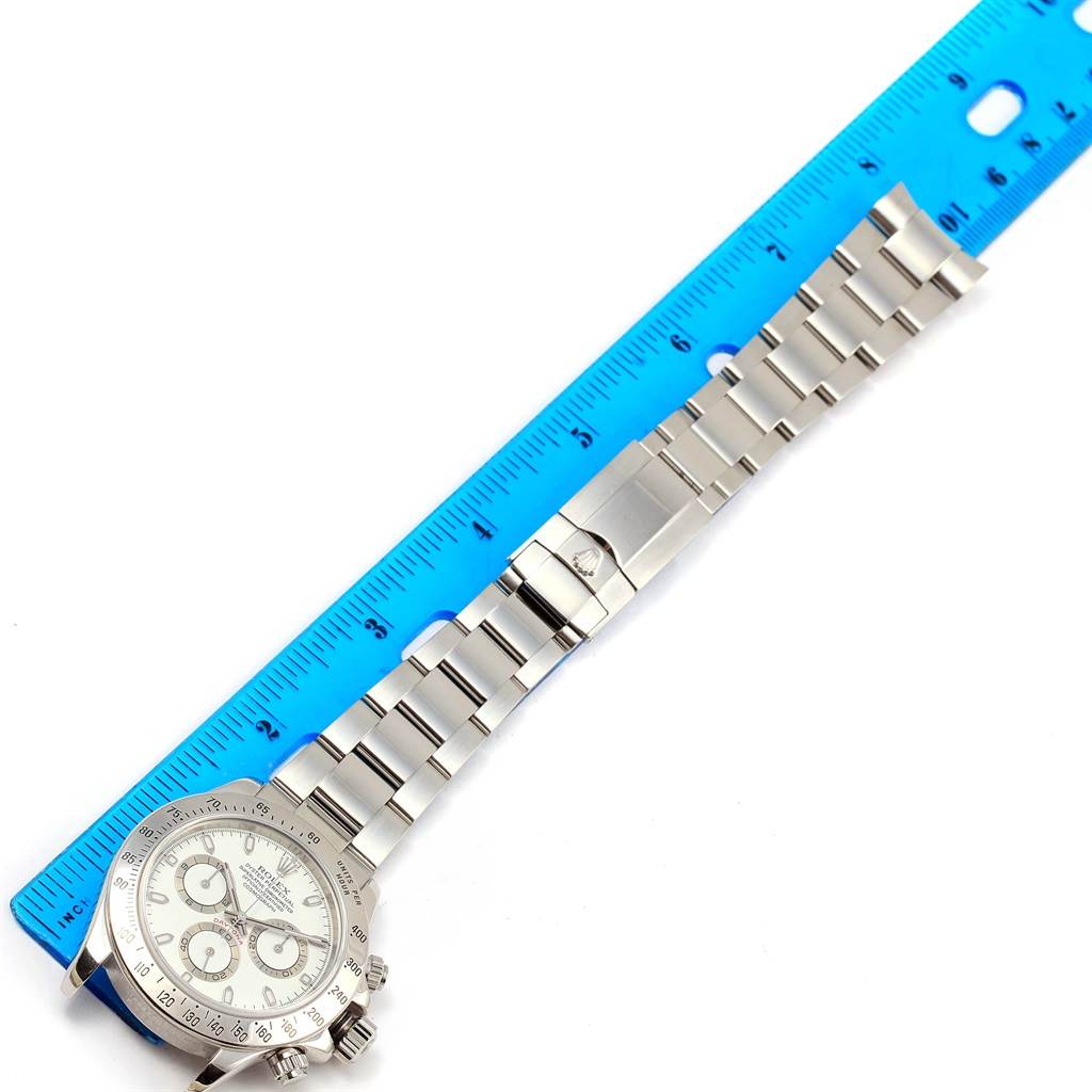 The image shows a full-length view of a Rolex Daytona 116520 Men's Stainless Steel White Dial 116520 Men's Stainless Steel White Dial watch, including its face, bracelet, and clasp, with a ruler for size reference.