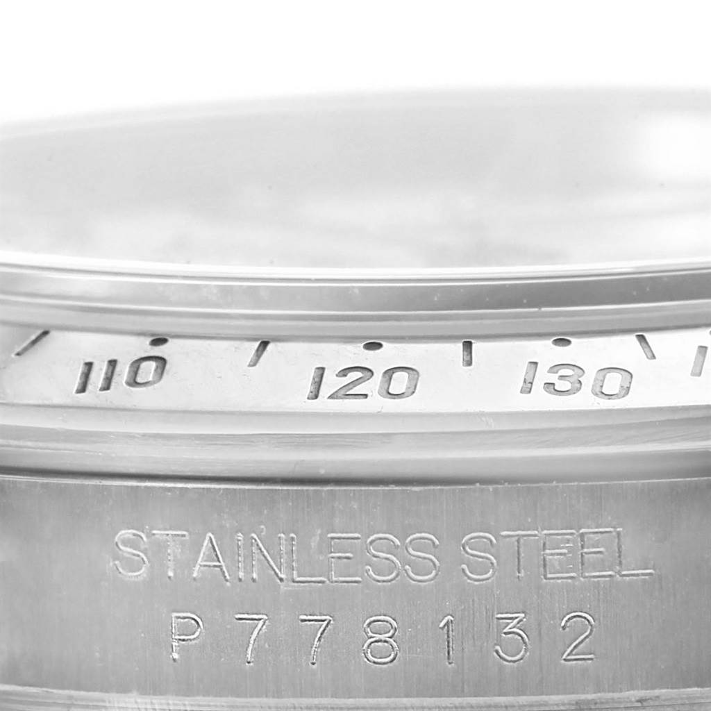 The image shows a close-up of the bezel and case side of a Rolex Daytona 116520 Men's Stainless Steel White Dial 116520 Men's Stainless Steel White Dial watch in stainless steel, displaying part of the tachymeter scale and serial number.