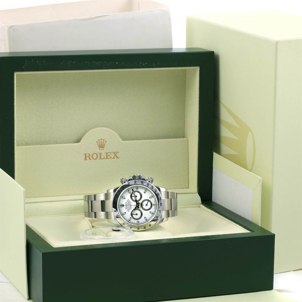 The Rolex Daytona 116520 Men's Stainless Steel White Dial 116520 Men's Stainless Steel White Dial watch is shown from the front, placed open in its original green and beige box.
