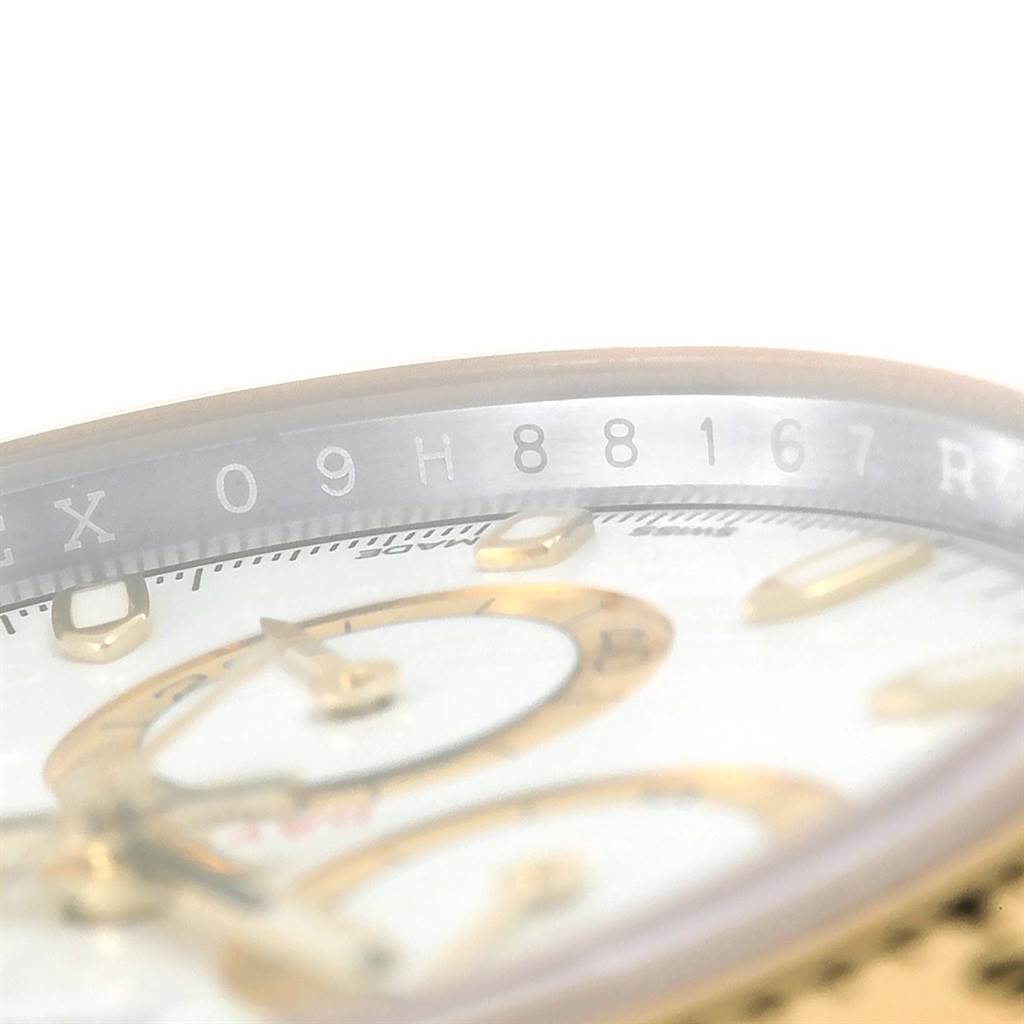 This image shows a close-up of the Rolex Daytona 116503 Men's Steel and Gold (two tone) White Dial 116503 Men's Steel and Gold (two tone) White Dial watch face, highlighting the bezel and part of the dial with indices.