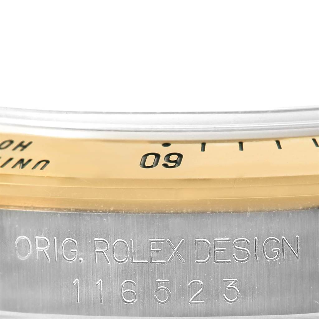 The image displays a close-up of the bezel and case side of a Rolex Daytona 116523 Men's Steel and Gold (two tone) Grey Dial 116523 Men's Steel and Gold (two tone) Grey Dial, featuring its engraved model number.