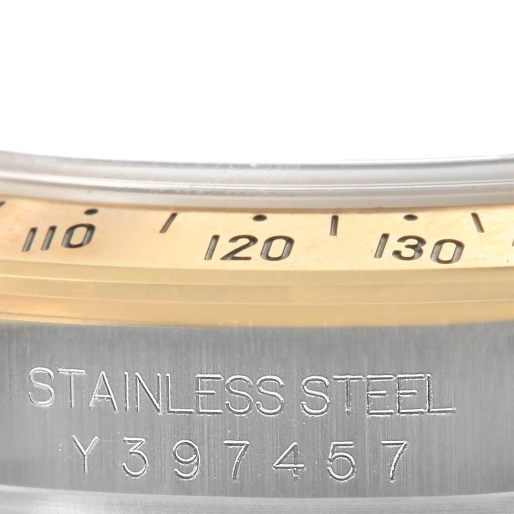 This image displays a close-up angle of the bezel and case side of a Rolex Daytona 116523 Men's Steel and Gold (two tone) Grey Dial 116523 Men's Steel and Gold (two tone) Grey Dial watch, with serial number details engraved.