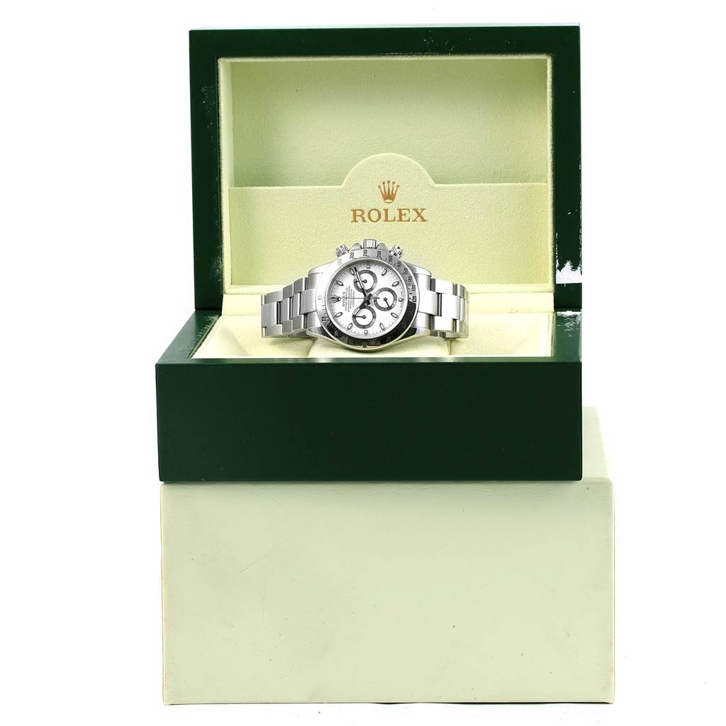 The image shows a front view of a Rolex Daytona 116520 Men
s Stainless Steel White Dial 116520 Men
s Stainless Steel White Dial watch in its green and cream-colored branded presentation box.