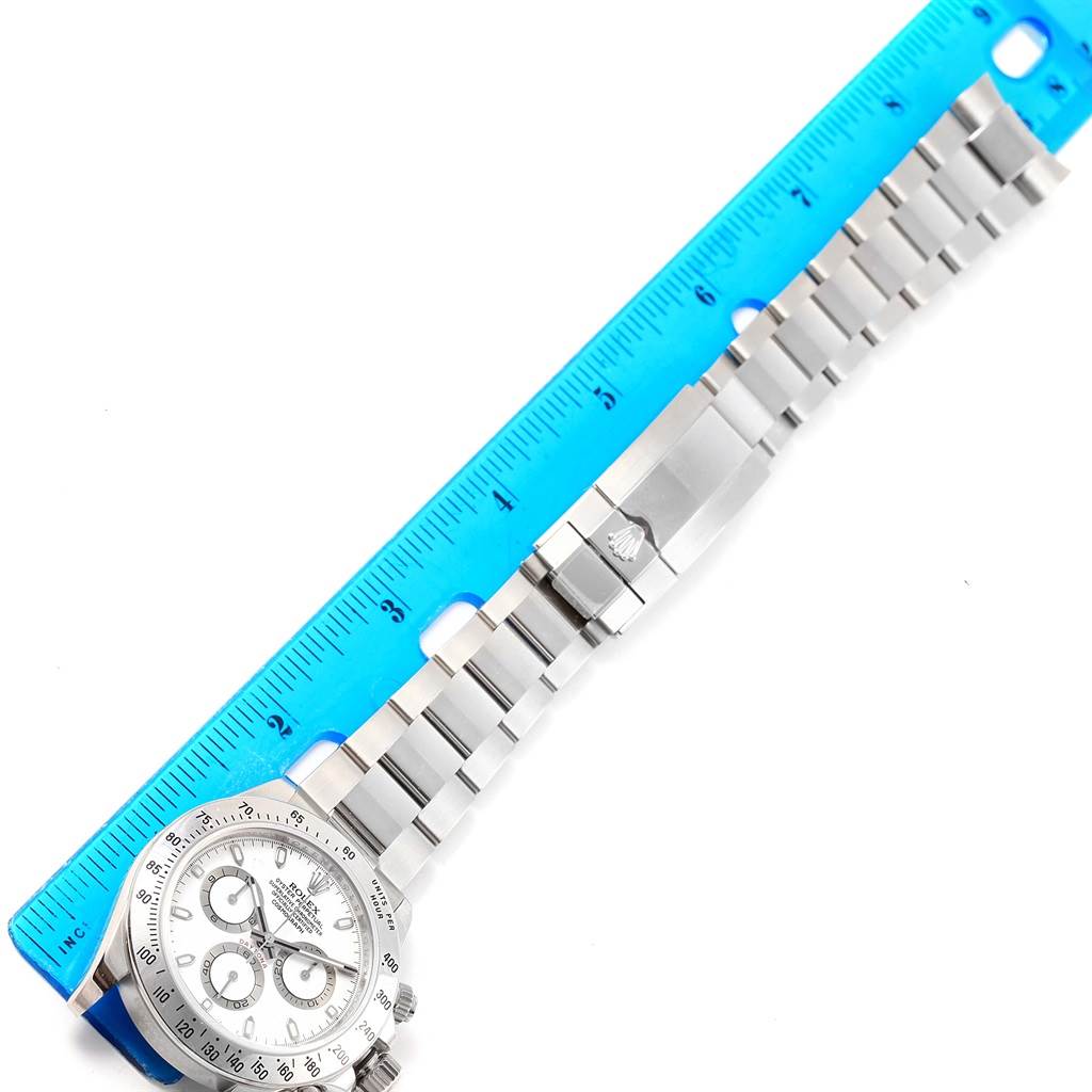 The image shows the Rolex Daytona 116520 Men's Stainless Steel White Dial 116520 Men's Stainless Steel White Dial watch with its full bracelet and clasp, measured against a blue ruler.