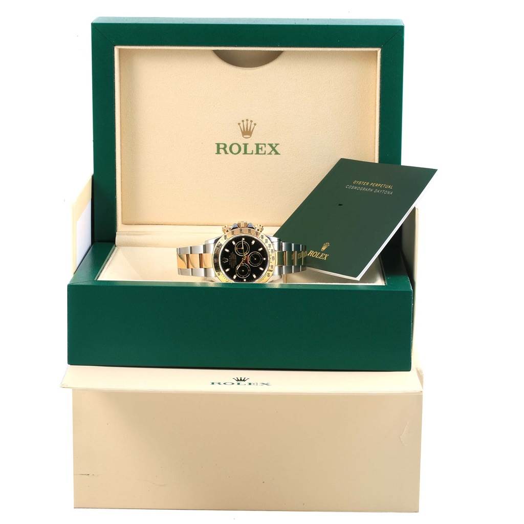 The image shows a Rolex Daytona 116523 Men's Steel and Gold (two tone) Black Dial 116523 Men's Steel and Gold (two tone) Black Dial watch in an open green Rolex box with paperwork on the side.