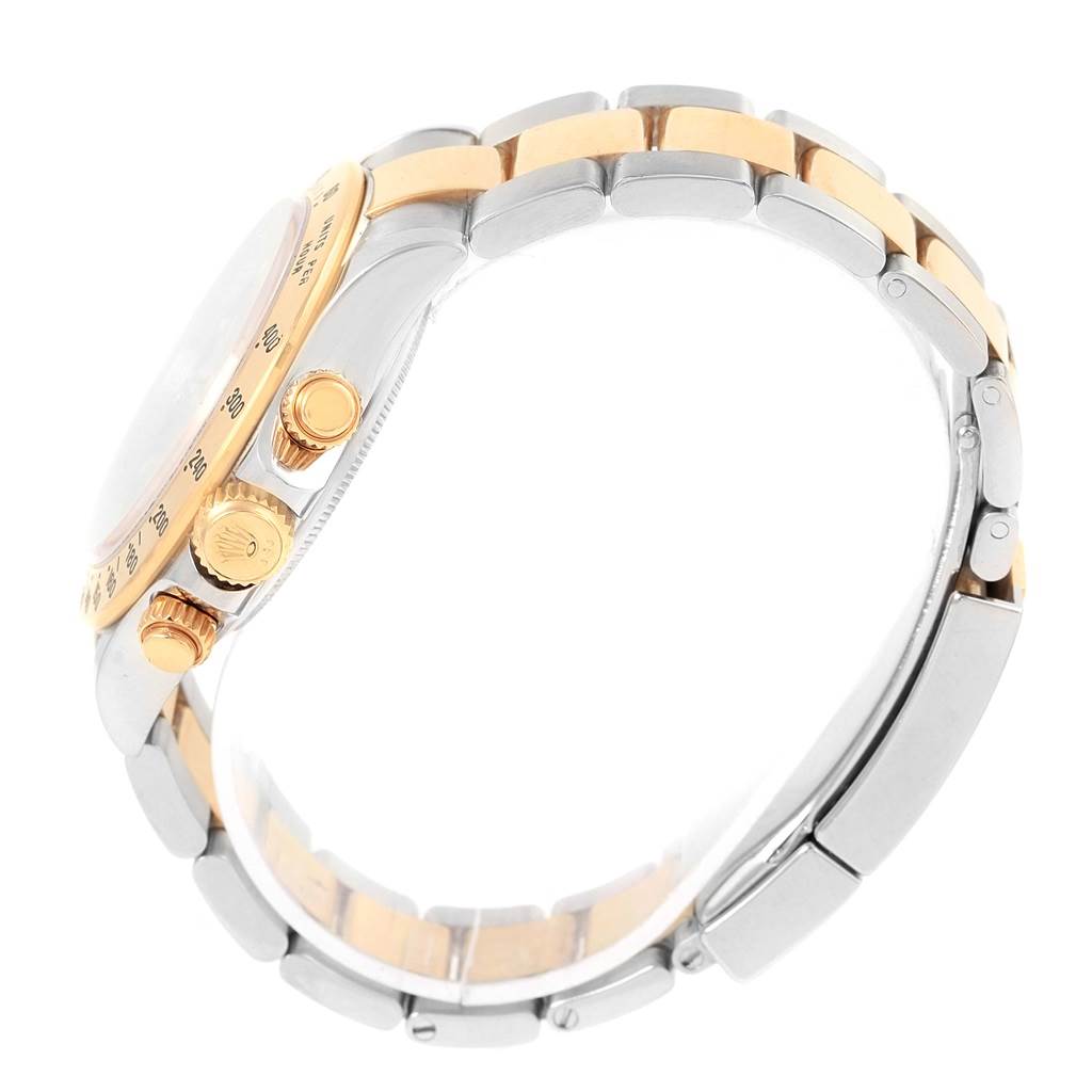 This side view of the Rolex Daytona 116523 Men's Steel and Gold (two tone) Grey Dial 116523 Men's Steel and Gold (two tone) Grey Dial watch shows its bracelet, bezel, and crown.