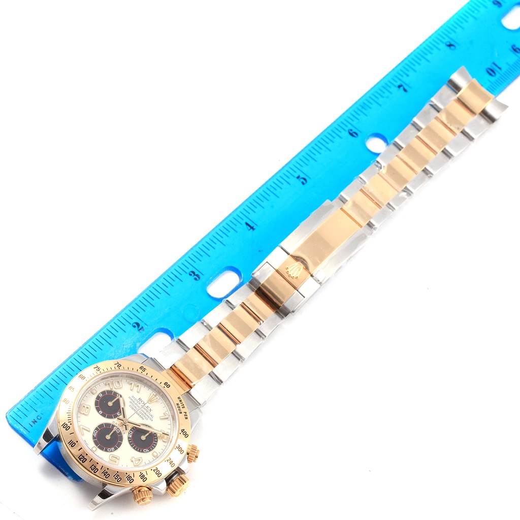 The image shows a Rolex Daytona 116523 Men's Steel and Gold (two tone) White Dial 116523 Men's Steel and Gold (two tone) White Dial watch placed next to a ruler, displaying the watch face and full bracelet.