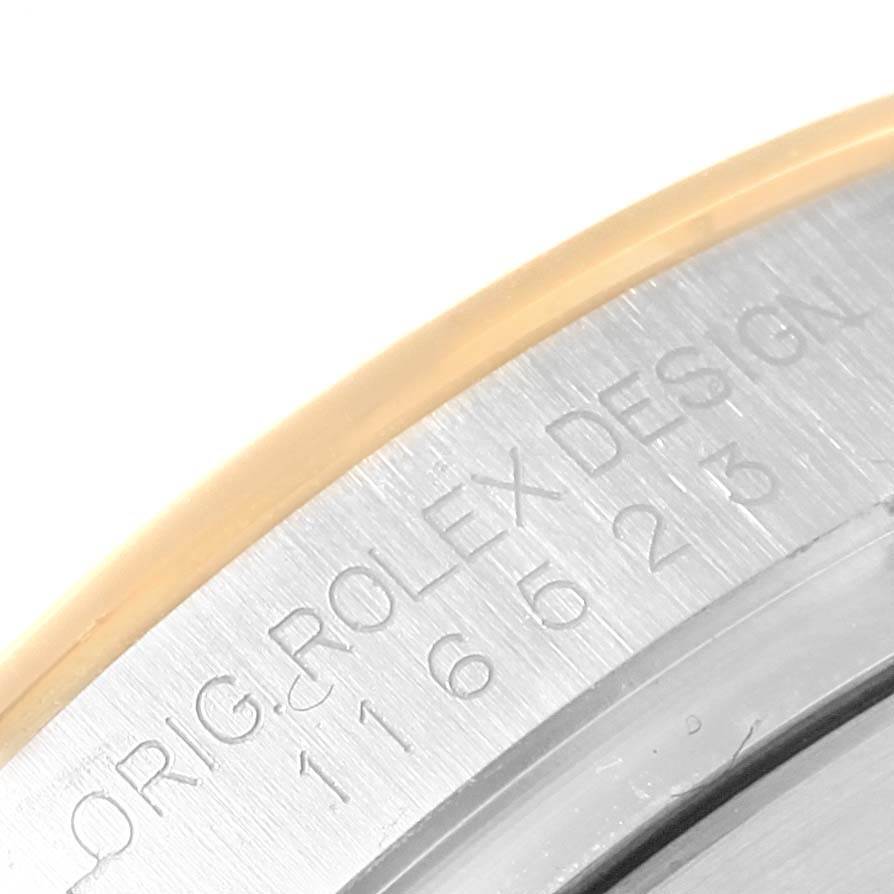 This close-up image shows part of the bezel and case of a Rolex Daytona 116523 Men's Steel and Gold (two tone) White Dial 116523 Men's Steel and Gold (two tone) White Dial watch, highlighting the engraving and model number.