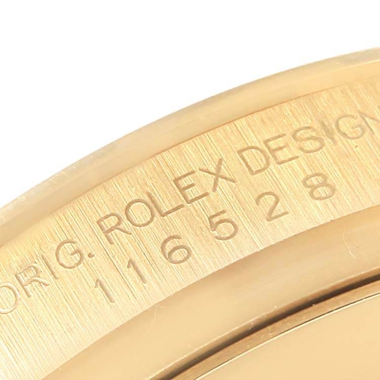 This image shows a close-up of the Rolex Daytona 116528 Men's Yellow Gold Champagne Dial 116528 Men's Yellow Gold Champagne Dial model's inner bezel with engraved text.