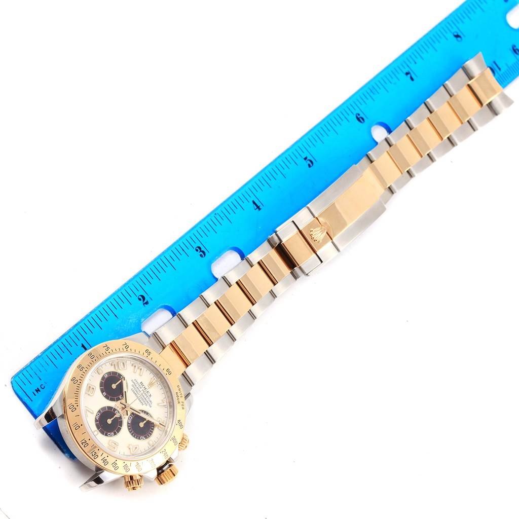 This image shows a Rolex Daytona 116523 Men's Steel and Gold (two tone) White Dial 116523 Men's Steel and Gold (two tone) White Dial watch with a gold and silver bracelet, laid flat with a ruler for scale.