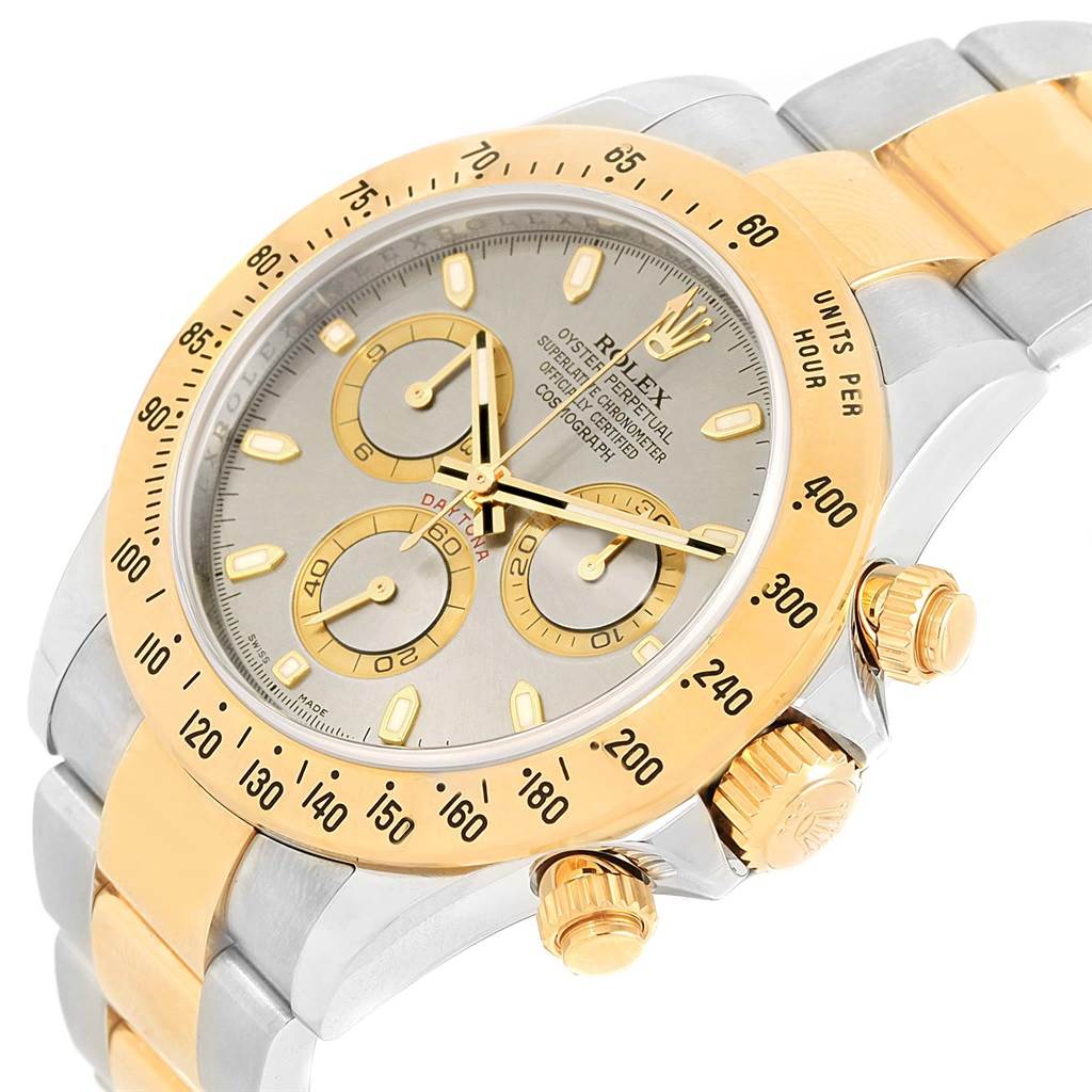 The image shows a close-up angled view of a Rolex Daytona 116523 Men's Steel and Gold (two tone) Grey Dial 116523 Men's Steel and Gold (two tone) Grey Dial, highlighting its bezel, chronograph dials, and crown.