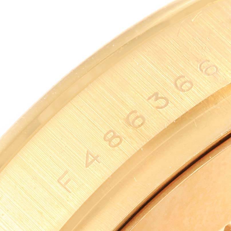 This close-up image shows the bezel of the Rolex Daytona 116528 Men's Yellow Gold Black Dial 116528 Men's Yellow Gold Black Dial model, highlighting its engraved numbers.