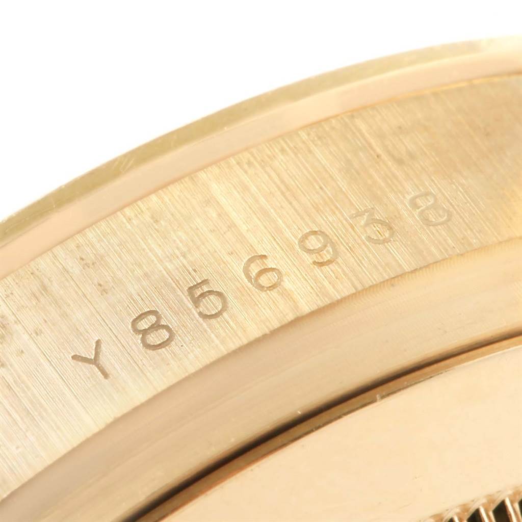 This close-up image shows the engraved serial number on the side of a Rolex Daytona 116528 Men's Yellow Gold White Dial 116528 Men's Yellow Gold White Dial watch case.