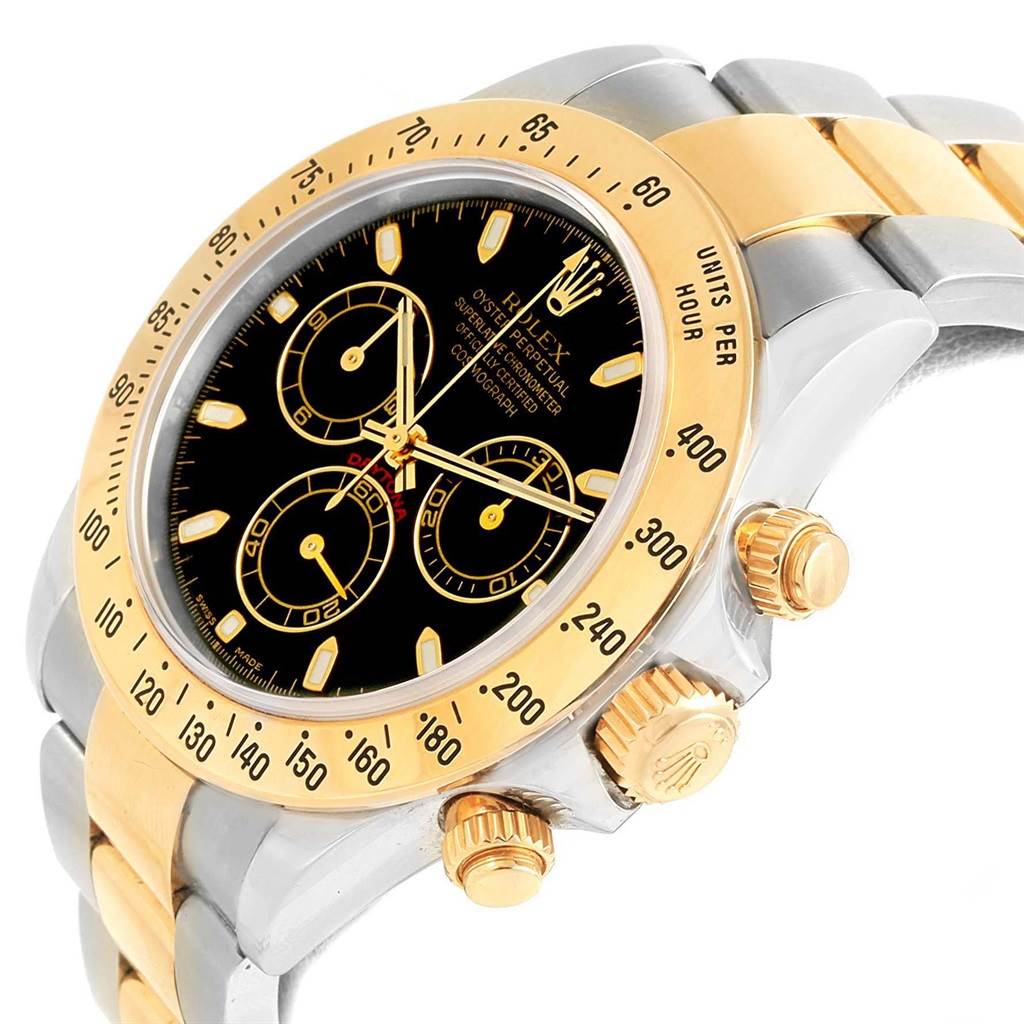 The image shows a close-up angled view of the Rolex Daytona 116523 Men's Steel and Gold (two tone) Black Dial 116523 Men's Steel and Gold (two tone) Black Dial watch, highlighting its bezel, dial, and crown.