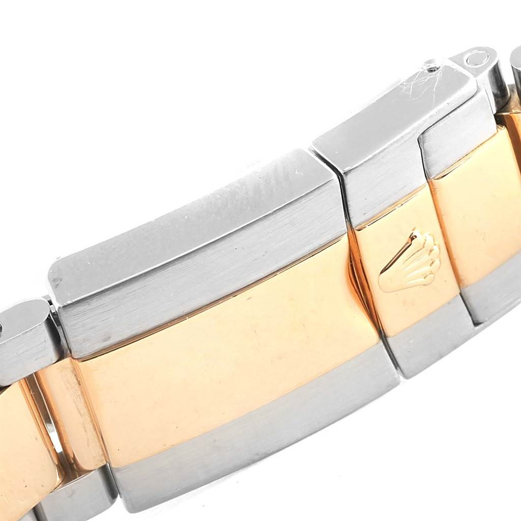 The image shows a close-up of the bracelet clasp of a Rolex Daytona 116523 Men's Steel and Gold (two tone) Mother of Pearl Dial 116523 Men's Steel and Gold (two tone) Mother of Pearl Dial watch, featuring both metal and gold links with the Rolex crown logo.