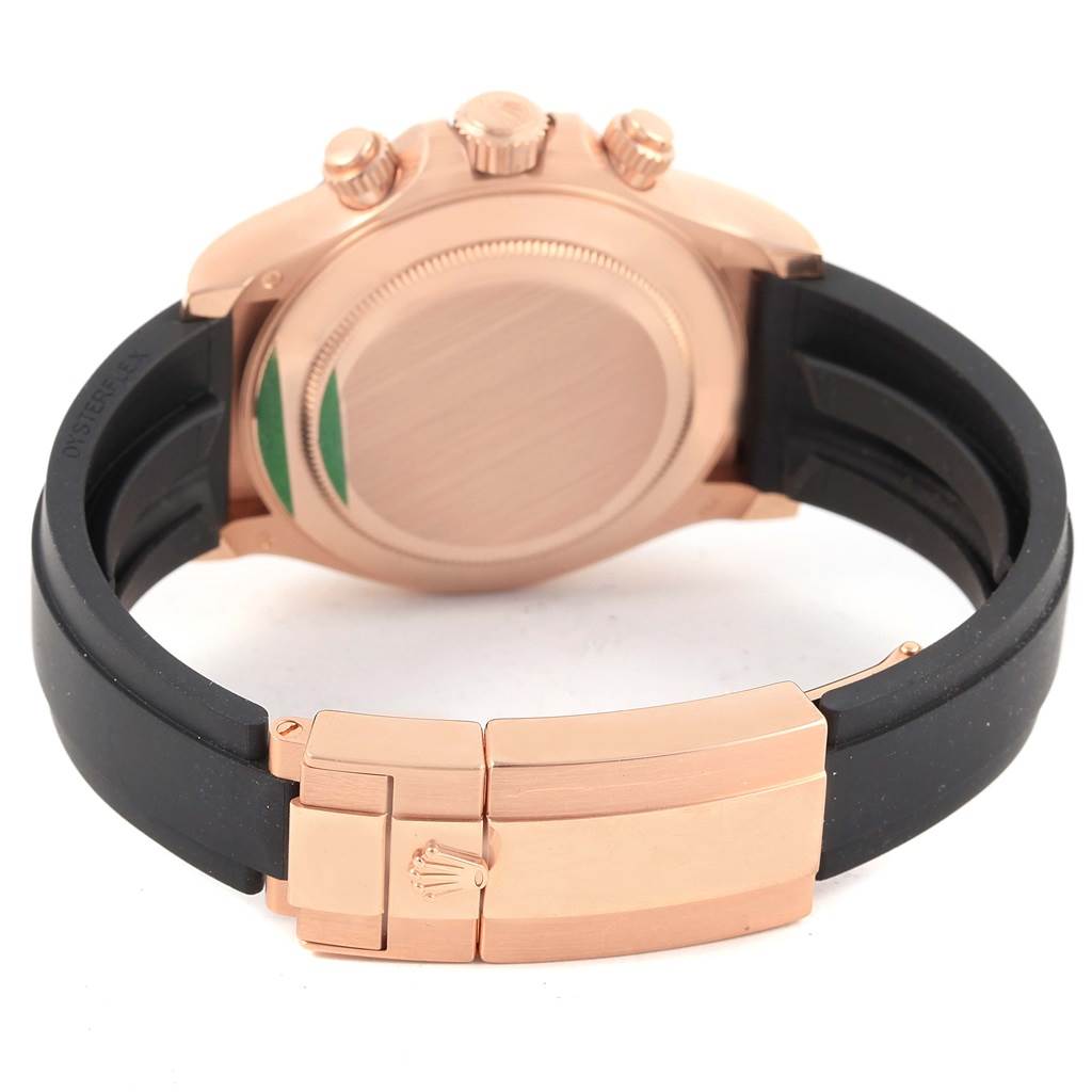 The image shows the back case and clasp of a Rolex Daytona 116515 Men's Rose Gold Brown Dial 116515 Men's Rose Gold Brown Dial watch, featuring a rose gold finish and a black rubber strap.