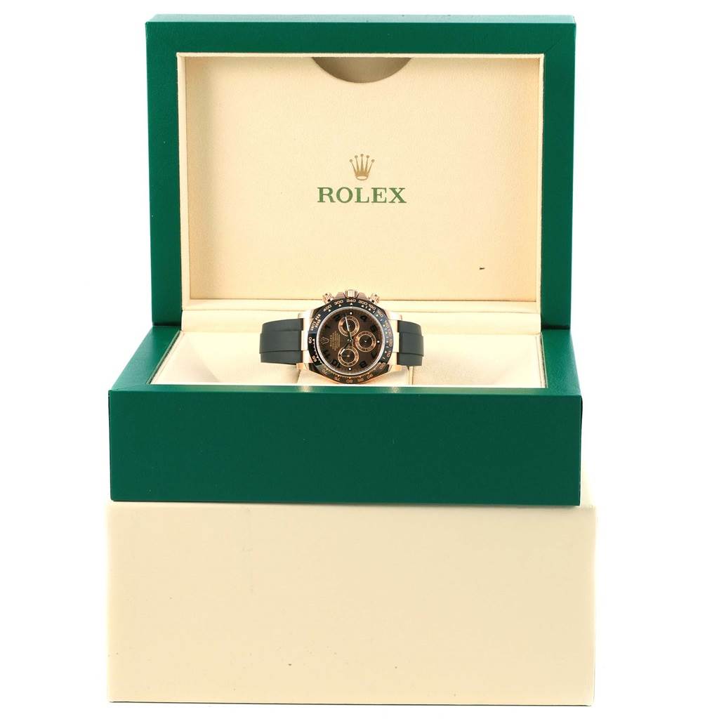 The Rolex Daytona 116515 Men's Rose Gold Brown Dial 116515 Men's Rose Gold Brown Dial watch is shown front-facing in an open green box with a beige interior.