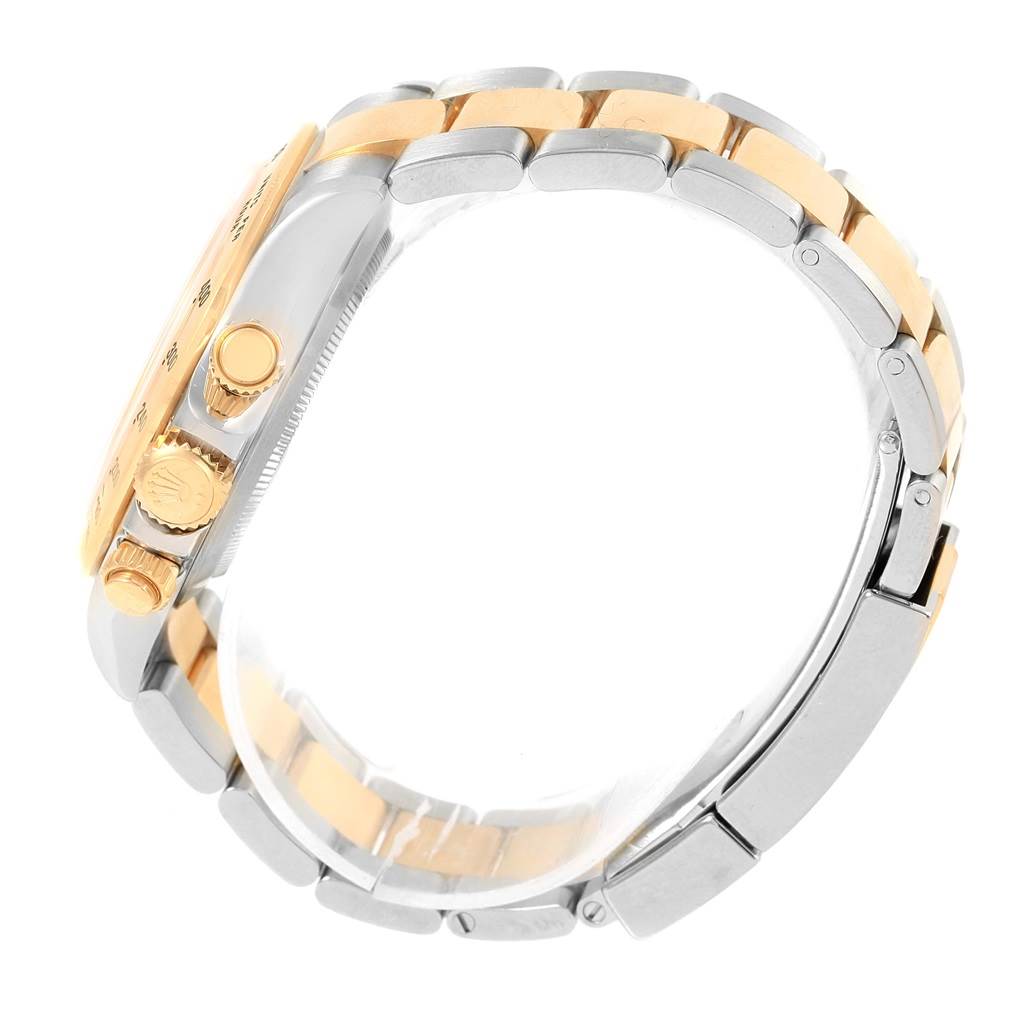 The image shows a side view of a Rolex Daytona 116523 Men's Steel and Gold (two tone) Champagne Dial 116523 Men's Steel and Gold (two tone) Champagne Dial watch, highlighting its crown, pushers, and two-tone bracelet.