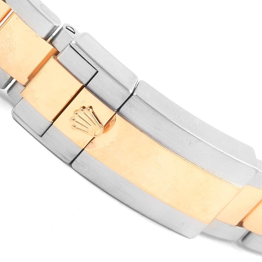 This image shows a close-up of the bi-metal bracelet of a Rolex Daytona 116523 Men's Steel and Gold (two tone) Champagne Dial 116523 Men's Steel and Gold (two tone) Champagne Dial watch, featuring the iconic Rolex crown logo on the clasp.