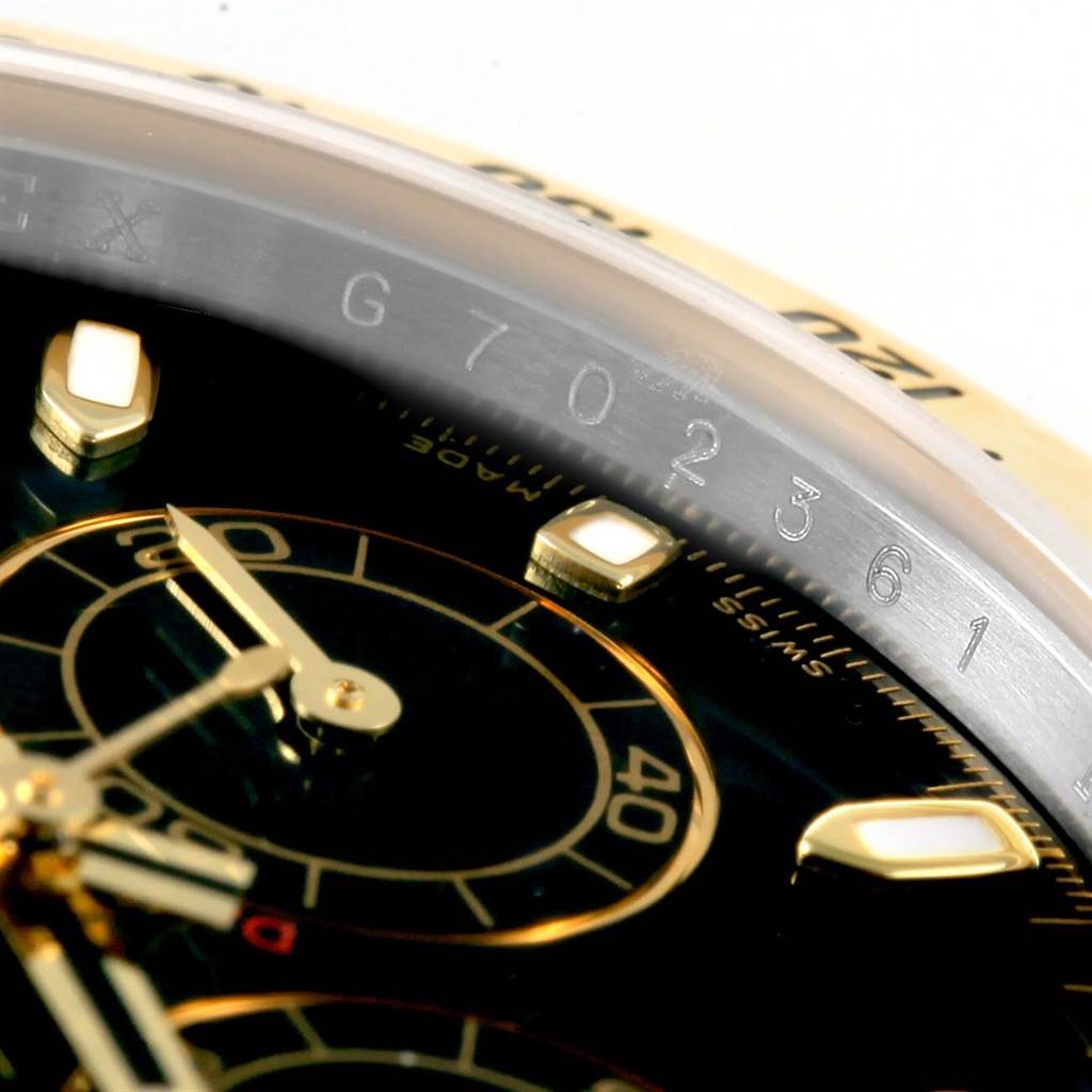 This close-up image of a Rolex Daytona 116523 Men's Steel and Gold (two tone) Black Dial 116523 Men's Steel and Gold (two tone) Black Dial watch shows the dial, subdials, and part of the bezel with engraved numbers.