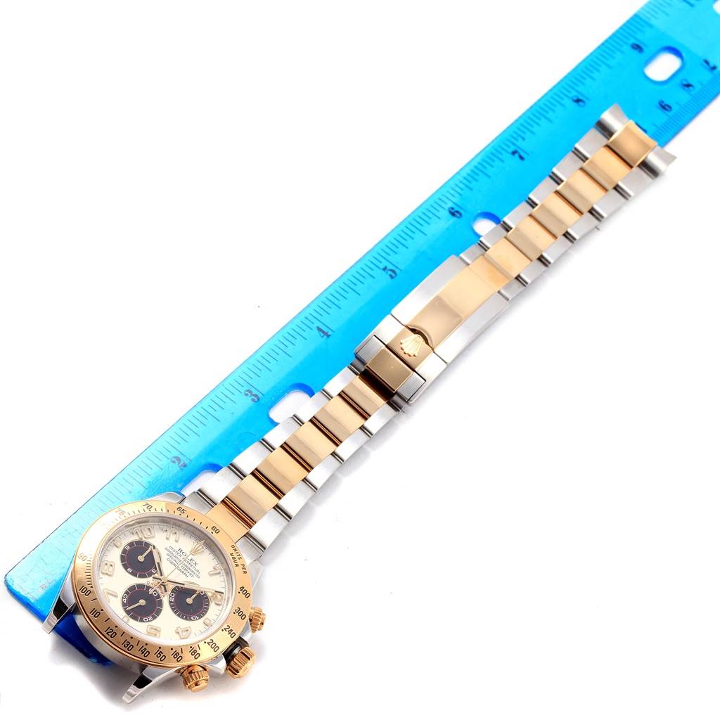 The Rolex Daytona 116523 Men's Steel and Gold (two tone) White Dial 116523 Men's Steel and Gold (two tone) White Dial watch is shown from a top view, highlighting the face, bezel, and full metal bracelet with a ruler for scale.